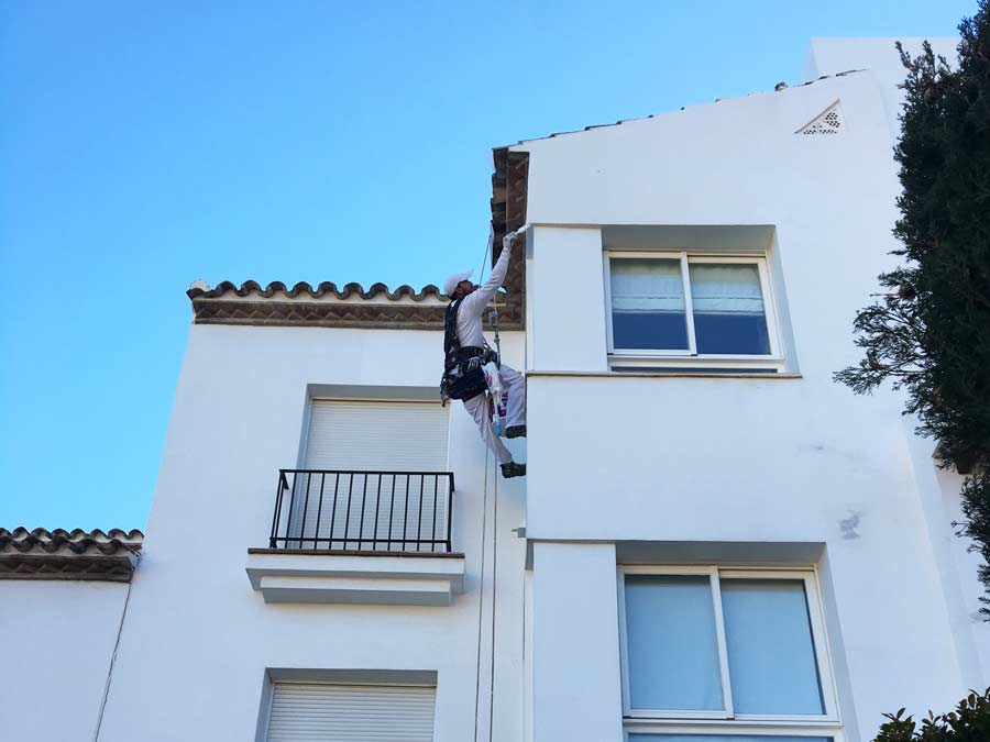 Trabajador de FRANJISUR pintando una fachada